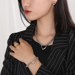 Detailed shot of silver heart pendant necklace and bracelet set with thick woven chains