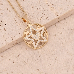 Detailed view of a gold pendant with zirconia, featuring star and MAMA heart design