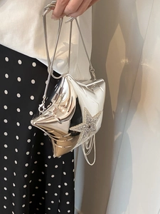 Detail of silver star-shaped acrylic bag with sparkling rhinestones and metal tassels