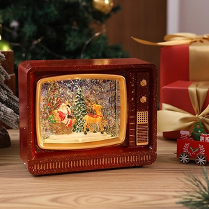 Close-up of retro TV Christmas snow globe with glitter, Santa Claus, and warm light