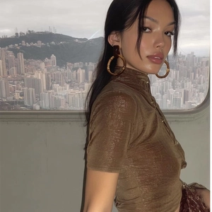 Elegant bamboo resin hoop earrings worn by model with city skyline background