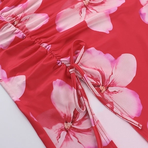 Detailed close-up of red floral dress featuring pink patterns and adjustable drawstring tie