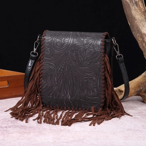 Detail of dark grey bohemian crossbody bag with floral embossing and brown fringes