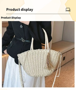Detail of handmade straw tote bag featuring brown tassel and large pearl accent