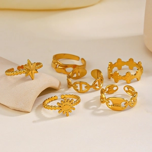 Set of six gold-plated celestial rings with star and moon designs on beige display