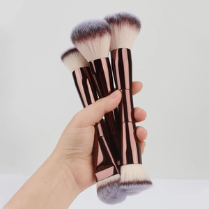 Close-up of double-ended makeup brushes with metallic handles and dual-tone synthetic bristles