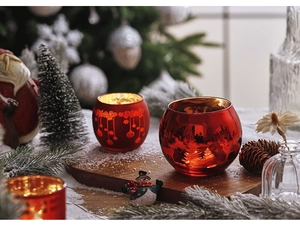 Detail of red glass candle holders featuring gold interior and Christmas tree silhouette