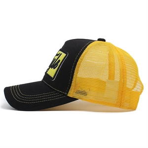 Close-up of black mesh cap with yellow contrast stitching and rectangle 3D embroidery