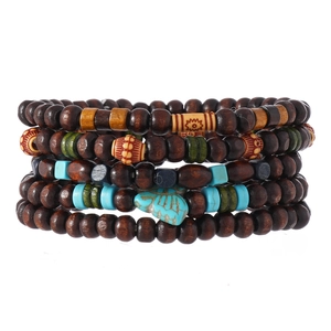 Détail d'un bracelet bohème en perles de bois avec papillon turquoise et breloques ethniques