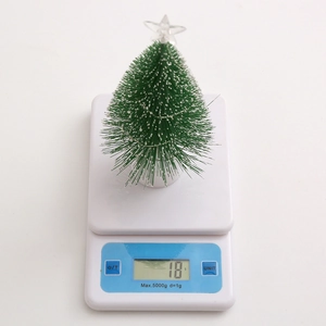 Detailed view of lightweight 18g mini artificial pine Christmas tree on a digital scale
