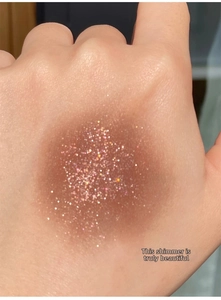 Macro shot of shimmering brown glitter eyeshadow swatch on skin with high pigmentation
