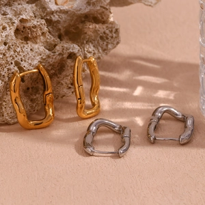 Detailed view of fluid irregular U-shape earrings in gold and silver metal finishes