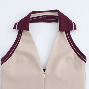 Dettaglio dell'abito halter beige stile preppy con colletto rosso scuro e zip frontale
