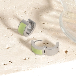 Detailed close-up of silver-tone stainless steel earrings with light green inlay on stone