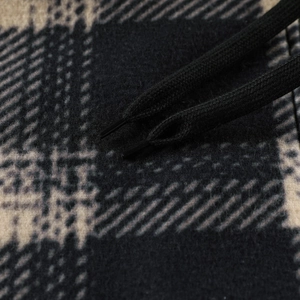 Detail of black woven drawstrings on a thick checkered fleece hoodie fabric