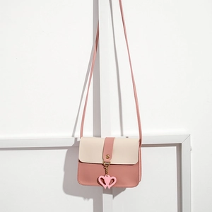 Detailed view of bicolor pink and white mini crossbody bag with heart charm and PU texture
