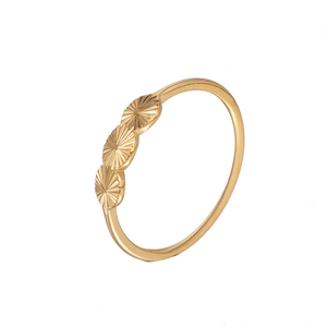 Detailed macro shot of golden ring featuring three sunburst engraved circles on band