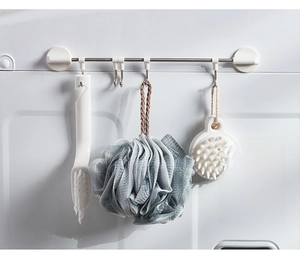 Detail of wall-mounted kitchen rail showing sliding hooks on a washing machine surface