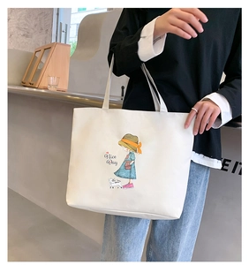 Detail of white canvas tote bag with girl and dog illustration and Nice Day text