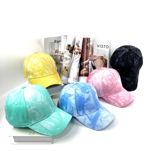 Primo piano di cappellini da baseball tie-dye nei colori giallo, verde, blu e rosa