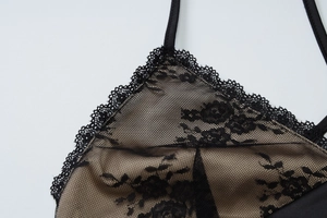Close-up of black floral lace embroidery and nude lining on backless halter dress