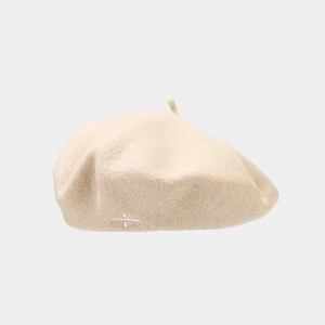 Détail du béret en laine beige avec broderie géométrique blanche et texture douce
