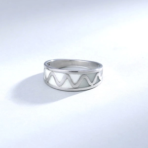 Detail of a 304 stainless steel wide ring featuring white luminous wavy pattern design