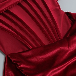Détail de la structure corsetée sur une robe de soirée en velours rouge foncé et tulle