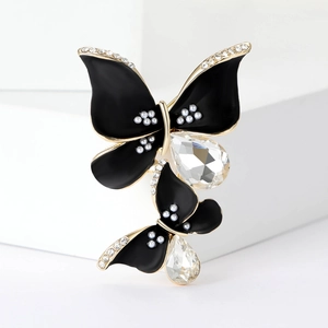 Elegant black butterfly brooch with rhinestones and pearls on golden metal wings