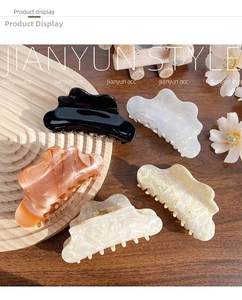 Detail of five cloud-shaped acetate hair claws in various marble and solid patterns