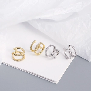 Macro detail of gold and silver double-layered ear cuffs with micro-pave cubic zirconia