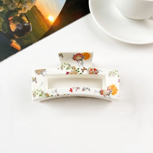 Close-up of a floral print rectangular hair claw clip with colorful bird and flower patterns