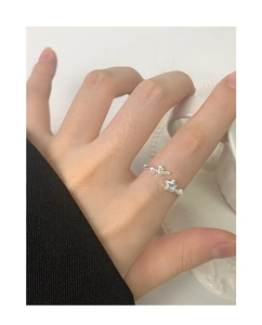 Close-up of a silver S925 star-shaped open ring worn by a model in a minimal setting