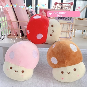 Detail of plush mushroom keychain showing soft texture, smiling face, and metal ring clasp