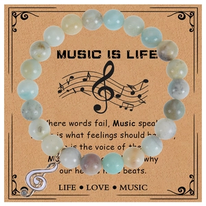 Détail du bracelet musical en pierres zebra 8mm avec breloque clé de sol sur sa carte