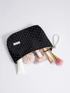 Polka dot travel cosmetic bag with pearl handle and pleated fabric in 45-degree view