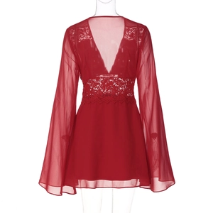 Détail d'une robe courte rouge en mousseline avec dentelle décolletée et manches évasées