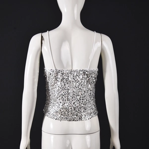 Vue détaillée d'un débardeur à paillettes argentées montrant le dos nu sur un mannequin blanc