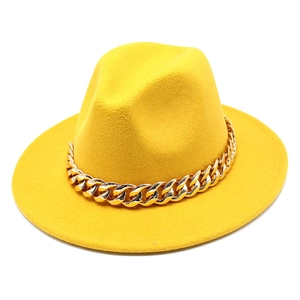 Detail view of yellow wool fedora hat featuring a chunky gold chain link decoration
