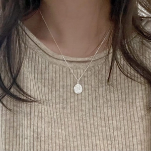 S925 Sterling Silver irregular oval coin pendant necklace shown on a model's neck