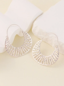 Detail of silver hollow half-moon earrings with vertical grill design on white rock