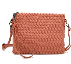 Detailed view of coral pink hand-woven leather texture and gunmetal hardware on bag