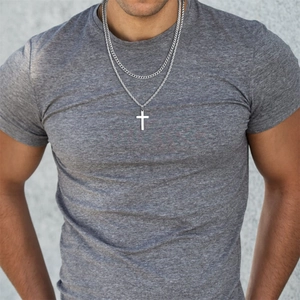 Close-up of double layered silver cross pendant necklace and cuban chain for men