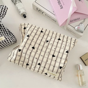 Détail macro d'une trousse à maquillage à carreaux et cœurs avec étiquette de marque