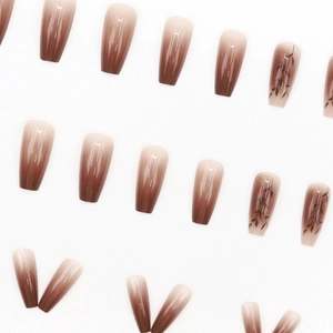 Long coffin fake nails with brown gradient and black leaf patterns on white background