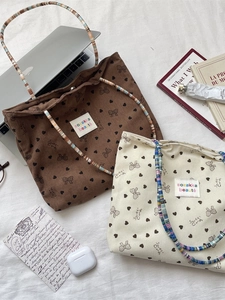 Corduroy tote bag with heart and bow patterns featuring colorful beaded shoulder straps