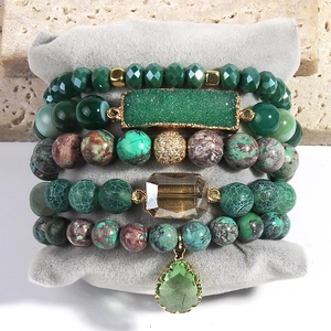 Detail of five-piece stacked bracelet set with green stone beads on velvet display
