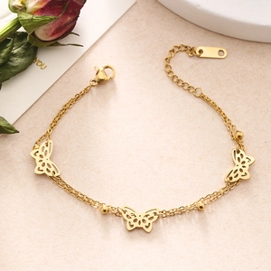 Detailed close-up of a double-strand golden butterfly bracelet with delicate charms