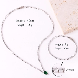 Detailed view of silver necklace and bracelet set with green teardrop zircon accents