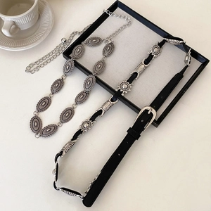 Vintage oval relief chain belt and black star-studded waist belt on a stylish tray